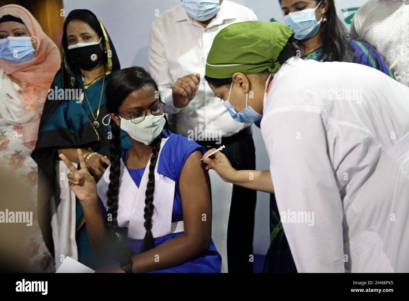 NOVEMBRE 01,2021,DHAKA,BANGLADESH- il Bangladesh ha iniziato a somministrare vaccini contro il coronavirus a studenti di età compresa tra 12-17 e 25 anni. La campagna di inoculazione è stata formalmente lanciata il 01,2021 novembre, Dhaka Bangladesh presso il centro di vaccinazione della scuola e del college ideale di Dhaka a Motijheel; Uno studente riceve la vaccinazione covid 19 Foto Stock