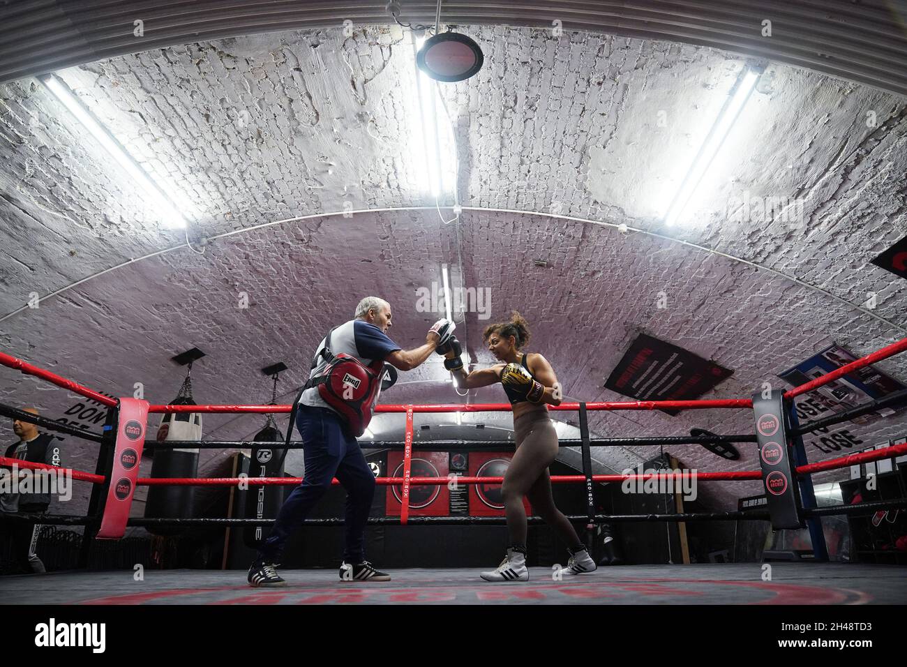 Il boxer professionista britannico Ruqsana Begum che fa il lavoro del tampone - per affilare le combinazioni specifiche che userà nella lotta - con il pulmann Steve Walters, durante una sessione di addestramento alla palestra di boxe di KO a Bethnal Green, Londra orientale, Prima del suo super flyweight lotta contro Tasha Boys Venerdì 5 novembre. Data di emissione: Lunedì 1 novembre 2021. Foto Stock