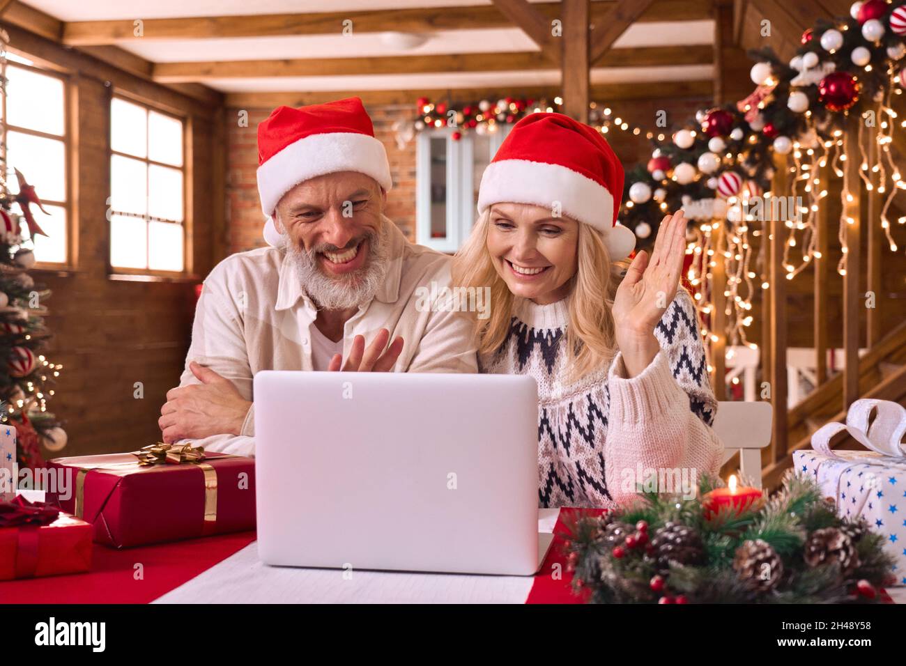 Felice matura coppia vecchia famiglia saluto su videochiamata di Natale con regali. Foto Stock
