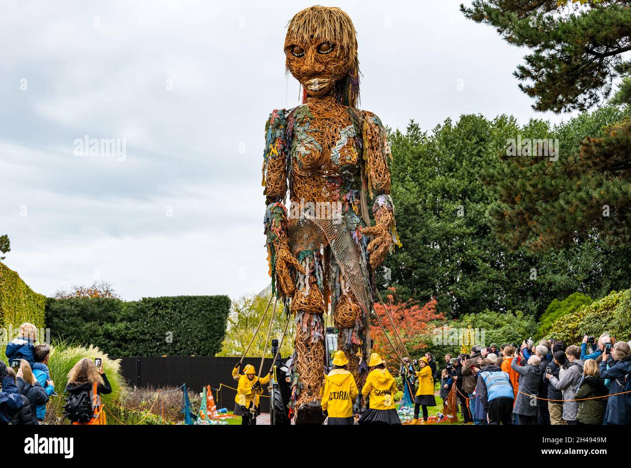 Persone che guardano l'evento teatrale Giant puppet Storm, materiali riciclati in forma, al Royal Botanic Garden, Edimburgo, Scozia, Regno Unito Foto Stock