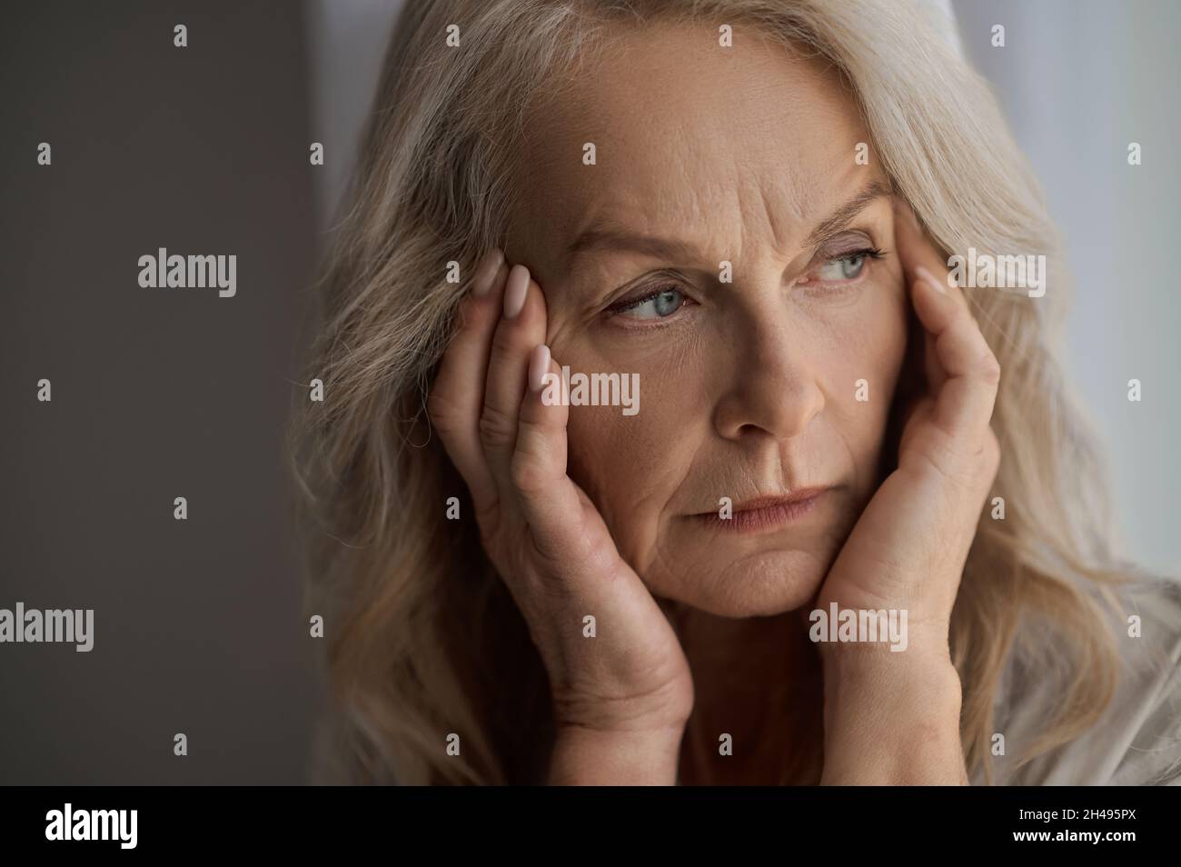 Triste donna matura che soffre di un mal di testa Foto Stock