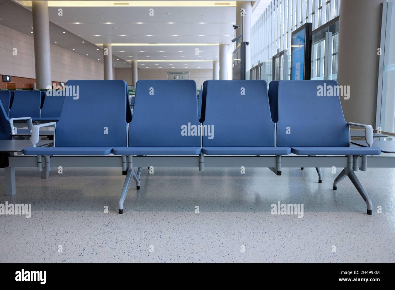 L'area d'attesa dell'aeroporto è vuota, con una grande finestra e nessuno, un posto pulito e spazioso Foto Stock