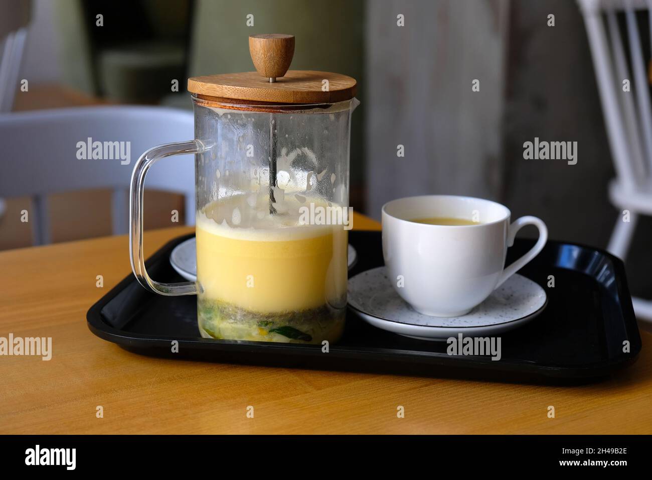 Tè con agrumi, rametti di rosmarino e burro. Tè tibetano con olio in una teiera di vetro e una tazza su un vassoio delizioso tè sano per raffreddori e per migliorare Foto Stock