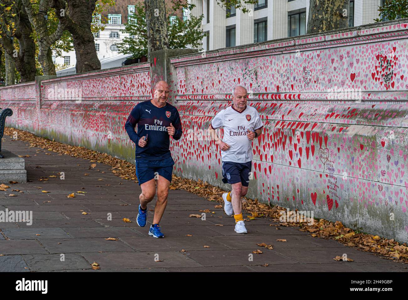 WESTMINSTER LONDRA, REGNO UNITO. 1 Nov 2021. Jogger che corrono lungo il muro commemorativo nazionale di Covid situato sul Tamigi Embankment come il numero di persone che test positivi per Covid nel Regno Unito è stato in aumento negli ultimi giorni a più di 50,000 casi in un giorno e gli scienziati temono un difficile inverno avanti. Il muro è un murale pubblico di cuori dipinto da volontari per commemorare le vittime della pandemia COVID-19 nel Regno Unito. Credit: amer Ghazzal/Alamy Live News Foto Stock