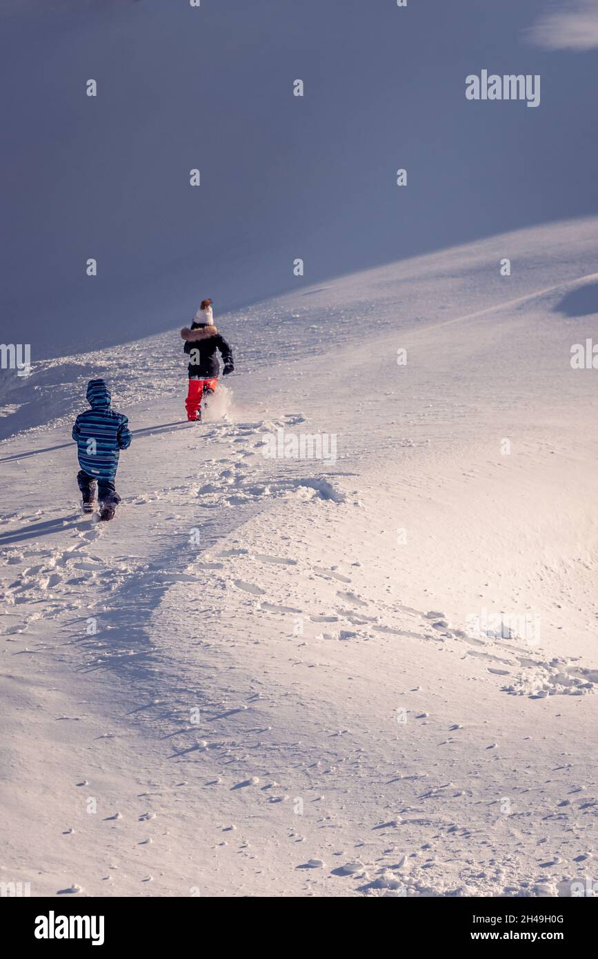 Bambini che giocano nella neve. Un ragazzo asiatico e una ragazza in sci-indossare escursioni in inverno. Buona infanzia. Foto Stock