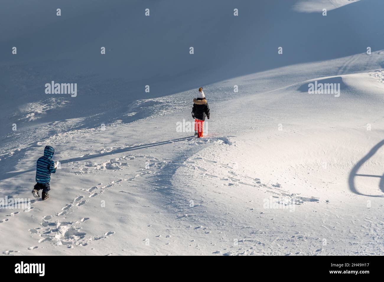 Bambini che giocano nella neve. Un ragazzo asiatico e una ragazza in sci-indossare escursioni in inverno. Buona infanzia. Foto Stock