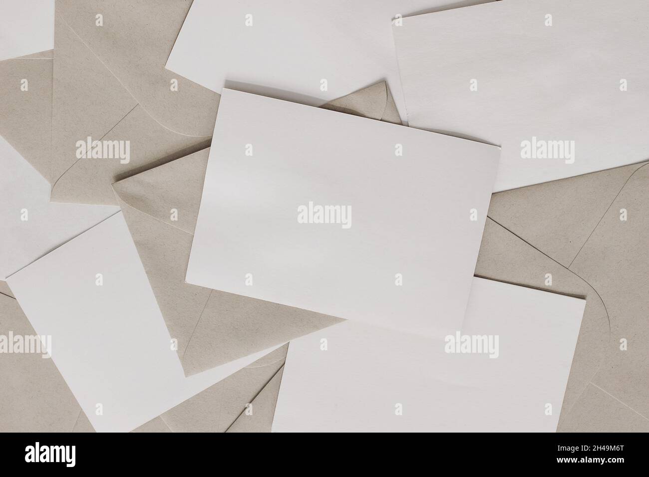 Set di lettere vuote con buste per il mestiere sul tavolo. Primo piano di biglietti d'auguri vuoti, inviti. Mockups di cancelleria. Posta, concetto di mailing. Disposizione piatta Foto Stock
