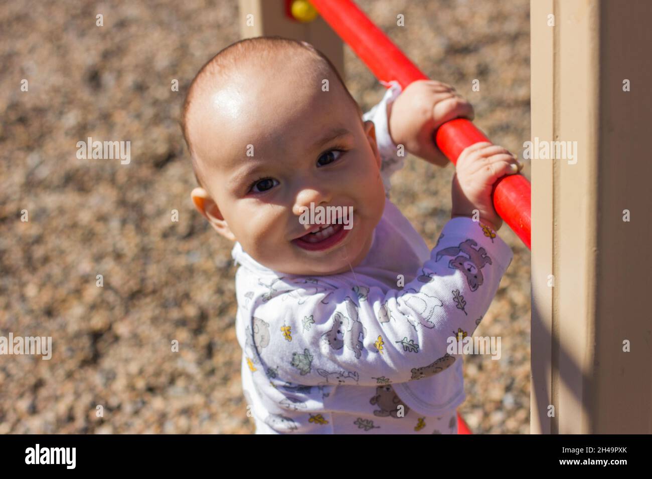 Il bambino piccolo carino che gioca al parco giochi per bambini. Foto Stock