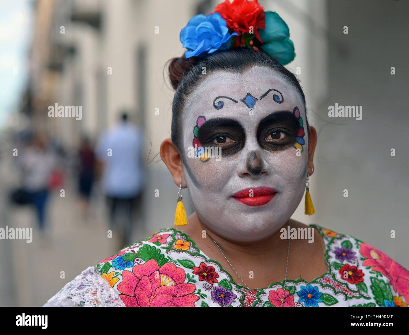 La donna messicana dello Yucatecan con il trucco tradizionale dipinto del viso (calavera) il giorno dei morti (dia de los Muertos) guarda lo spettatore. Foto Stock