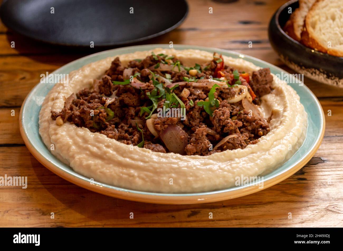 Hummus con agnello in cima. Piatto mediorientale Foto Stock