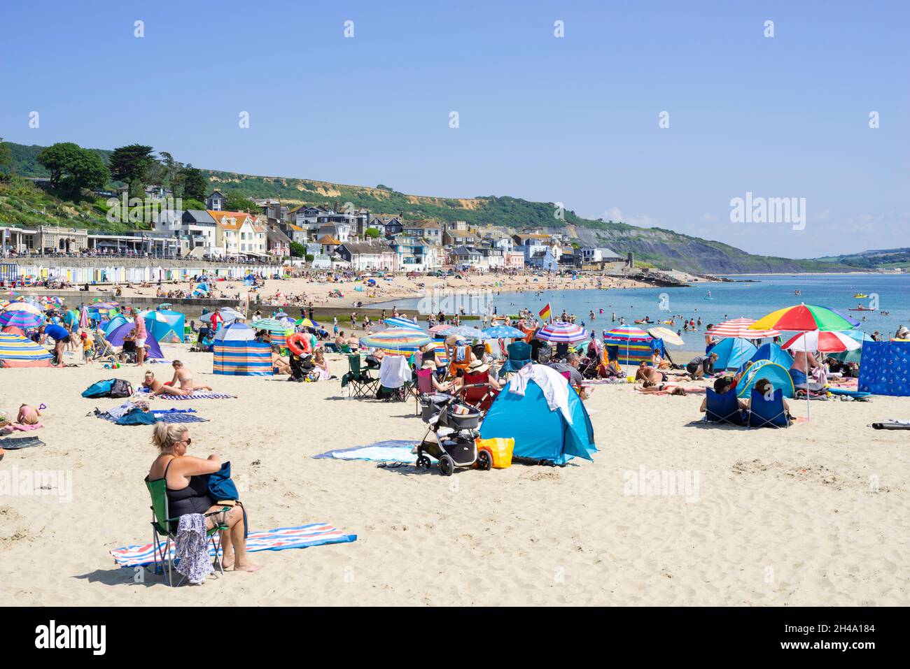Famiglia sulla spiaggia con pop up tende sulla spiaggia Sandy a Lyme Regis Dorset Inghilterra GB Europa Foto Stock