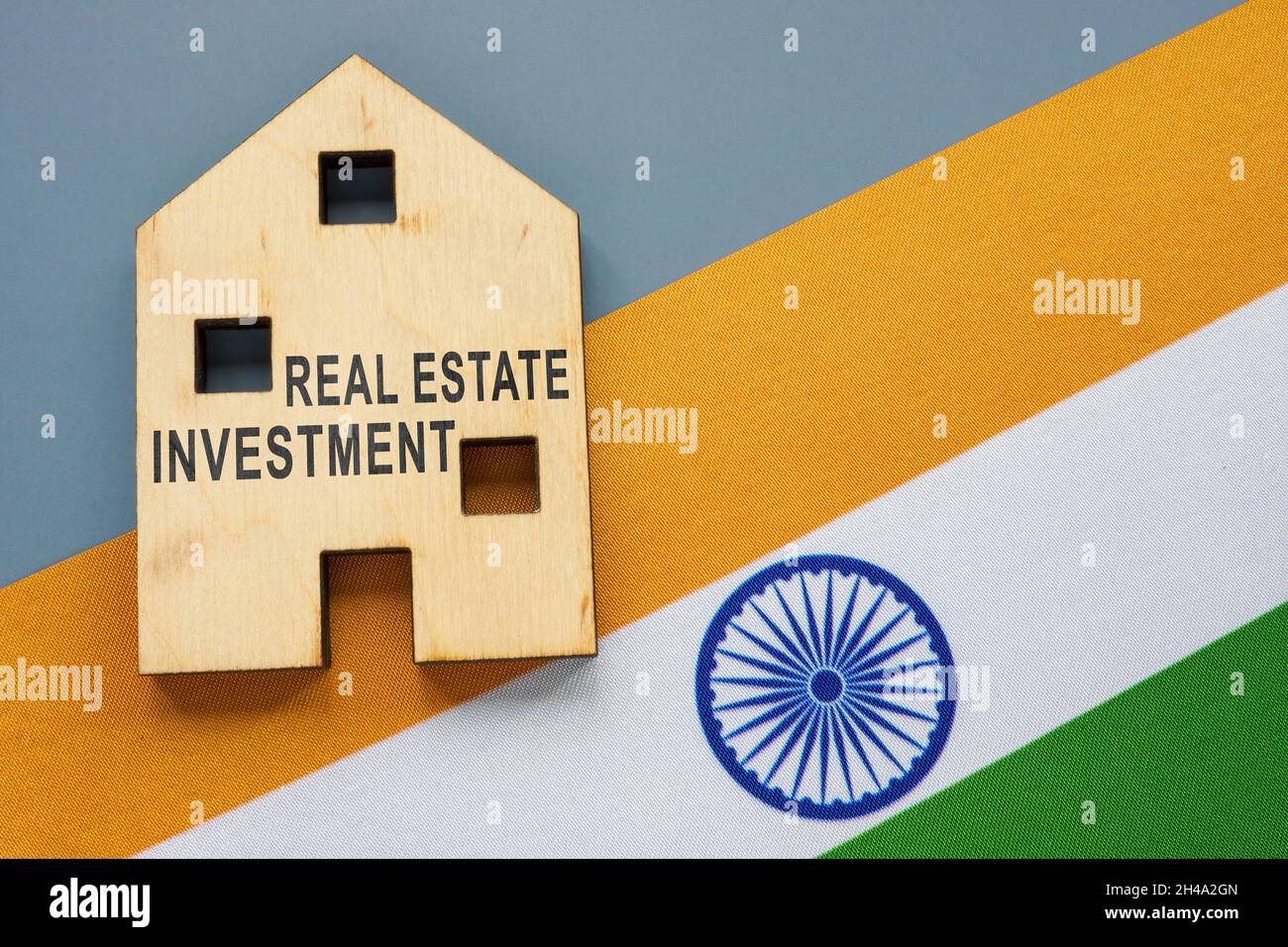 Concetto di investimento immobiliare. Bandiera indiana e modello di casa con iscrizione. Foto Stock
