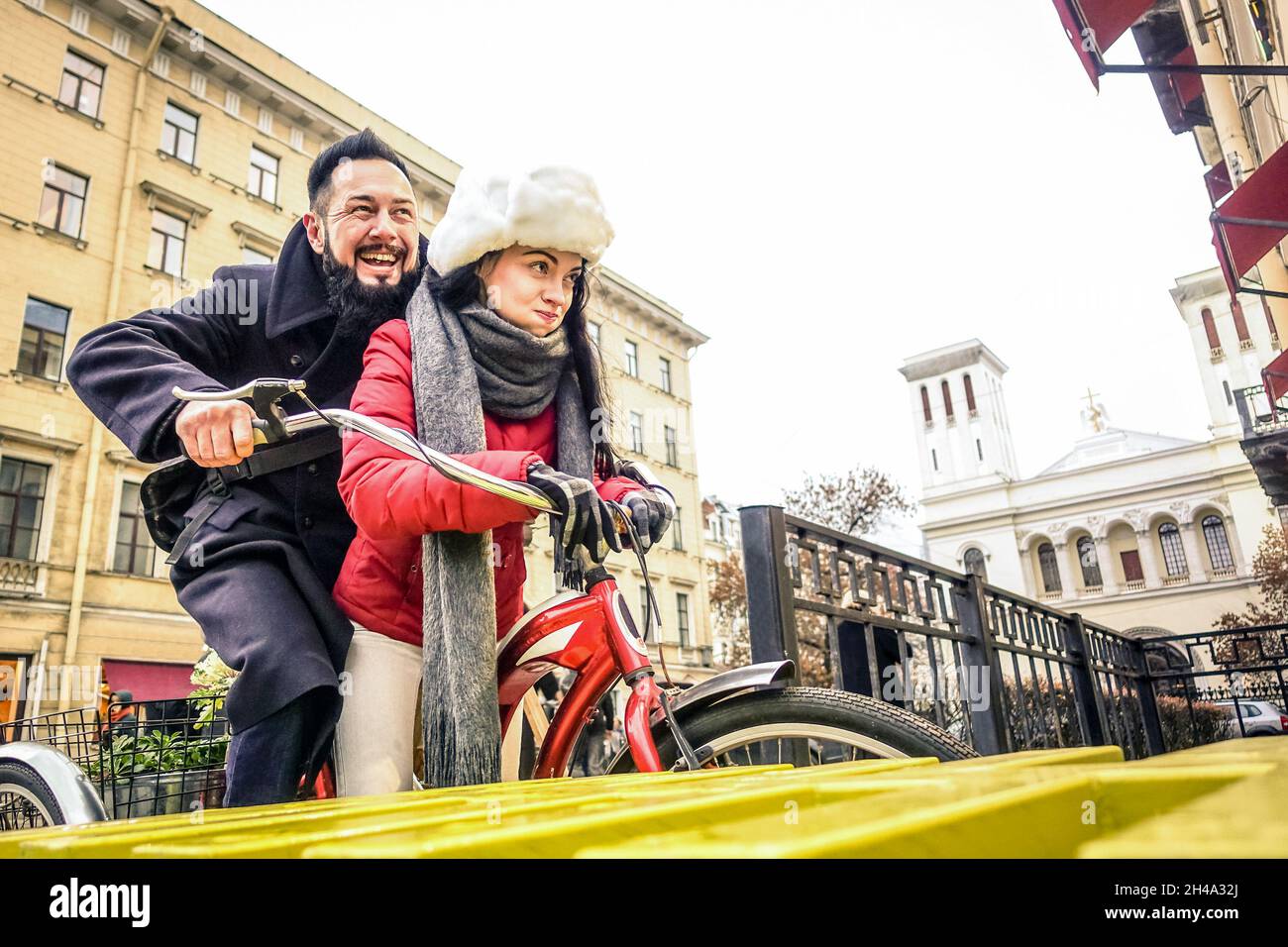 Felice coppia in amore godersi il tempo invernale all'aperto su bicicletta d'epoca - bell'uomo hipster con giovane donna divertirsi insieme Foto Stock