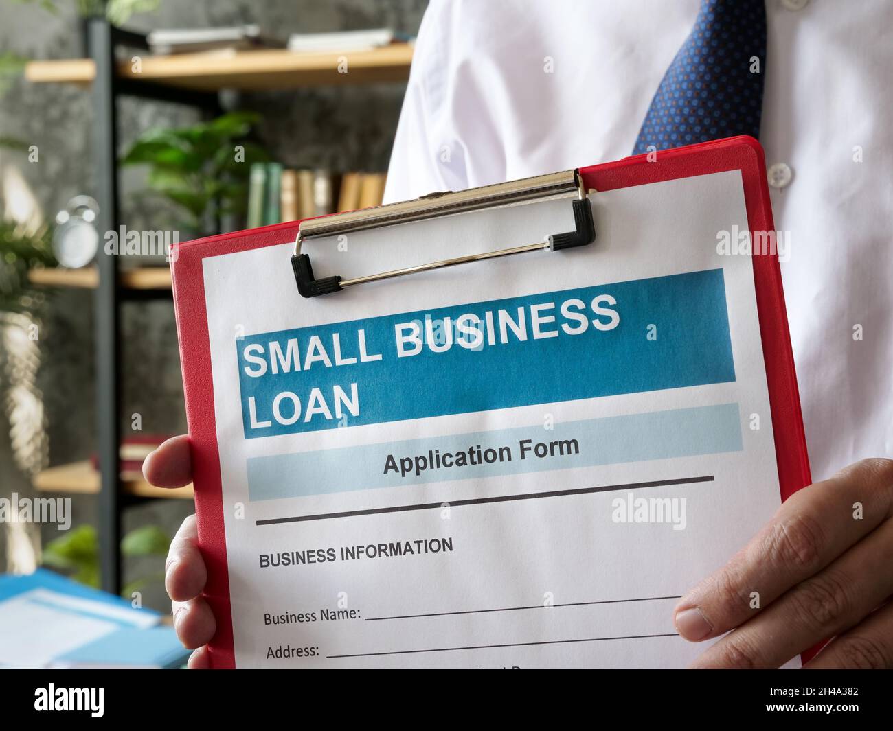 L'uomo mostra l'applicazione di prestito di piccola impresa con la cartella. Foto Stock