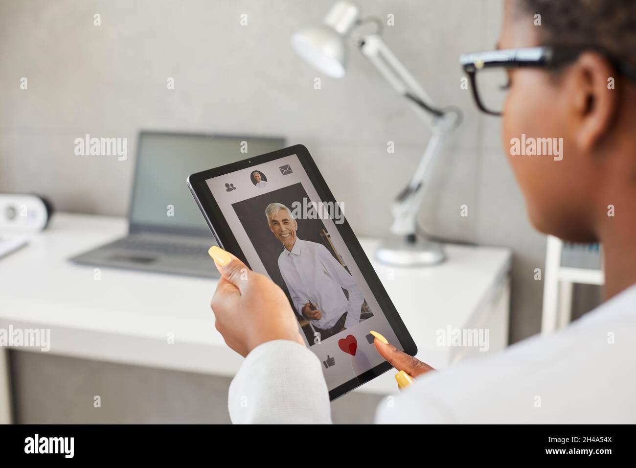 Donna sul luogo di datazione o nell'applicazione preme il cuore rosso come segno di simpatia per l'uomo bello. Foto Stock