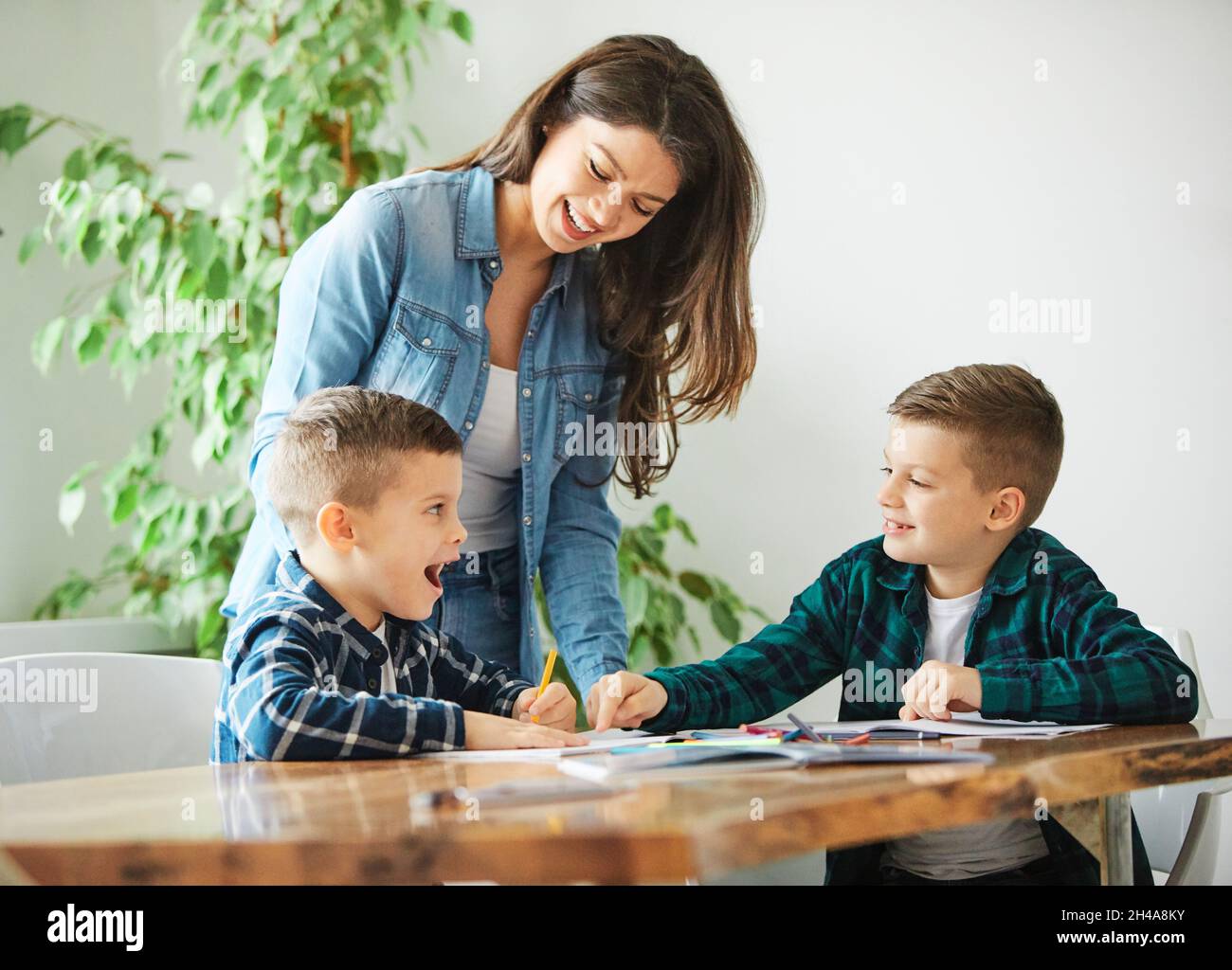 compiti di insegnamento istruzione madre figli figlio familiare infanzia insegnante classe Foto Stock
