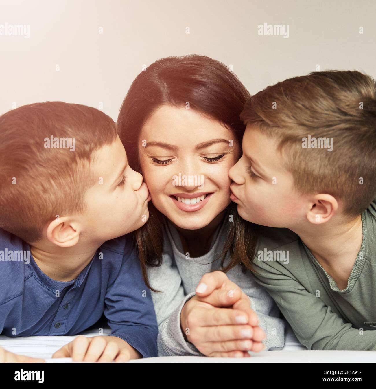 bambino ragazzo figlio madre bacio baciare amore felice famiglia cura infanzia genitore bambino ritratto letto camera da letto Foto Stock