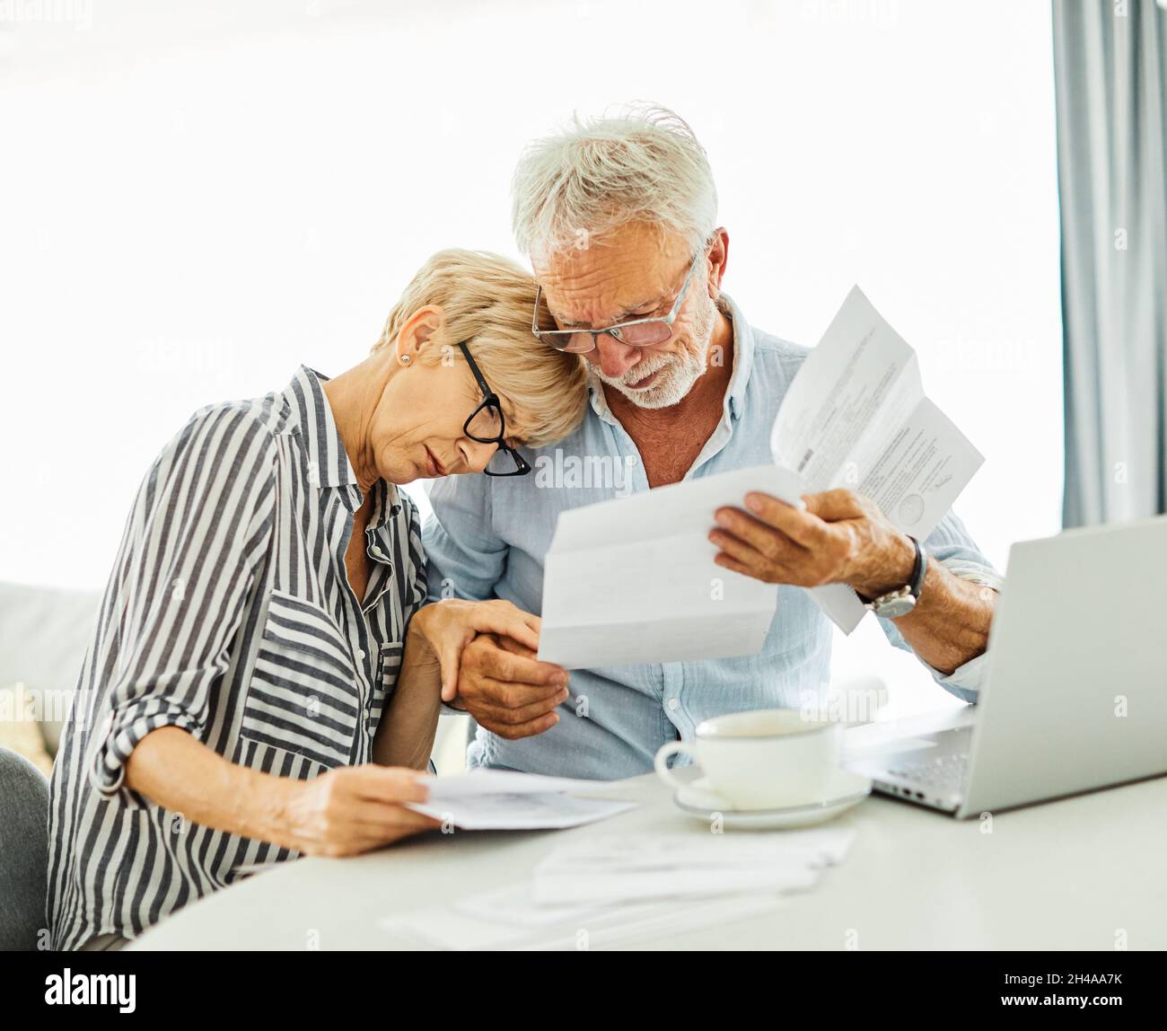 senior coppia donna uomo fattura finanza bilancio fiscale calcolatrice carta documento ritiro carta laptop Foto Stock