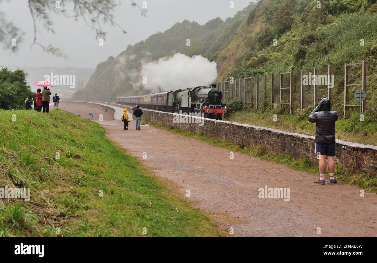 Treno a vapore sotto la pioggia. Gli appassionati si sfidano contro le intemperie per guardare il tour ferroviario di Mayflower passando da Sprey Point a Teignmouth, nel Devon meridionale. Foto Stock