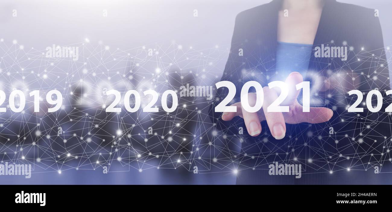 Anno di carico 2021. Inizia concetto. Mano touch schermo digitale ologramma 2021 segno sulla città luce sfondo sfocato. Concept inizio nuovo anno 2021. Foto Stock