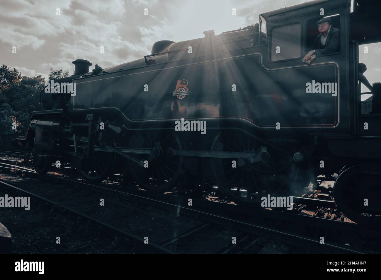 Fotografia suggestiva e nostalgica del treno a vapore, il Moorlander, che lascia la stazione di Grosmont sulla North York Moors Heritage Railway con treno in macchina Foto Stock
