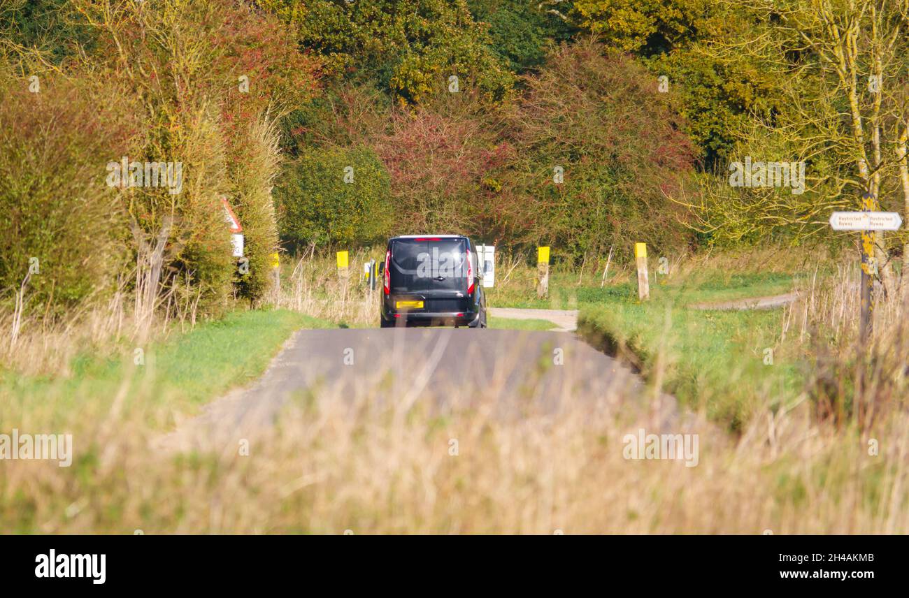 Black Ford Transit furgone personalizzato che guida attraverso la panoramica campagna autunnale Foto Stock