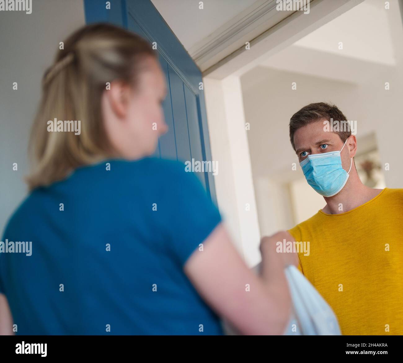 L'uomo mascherato trasporta il cibo durante la pandemia. Foto Stock