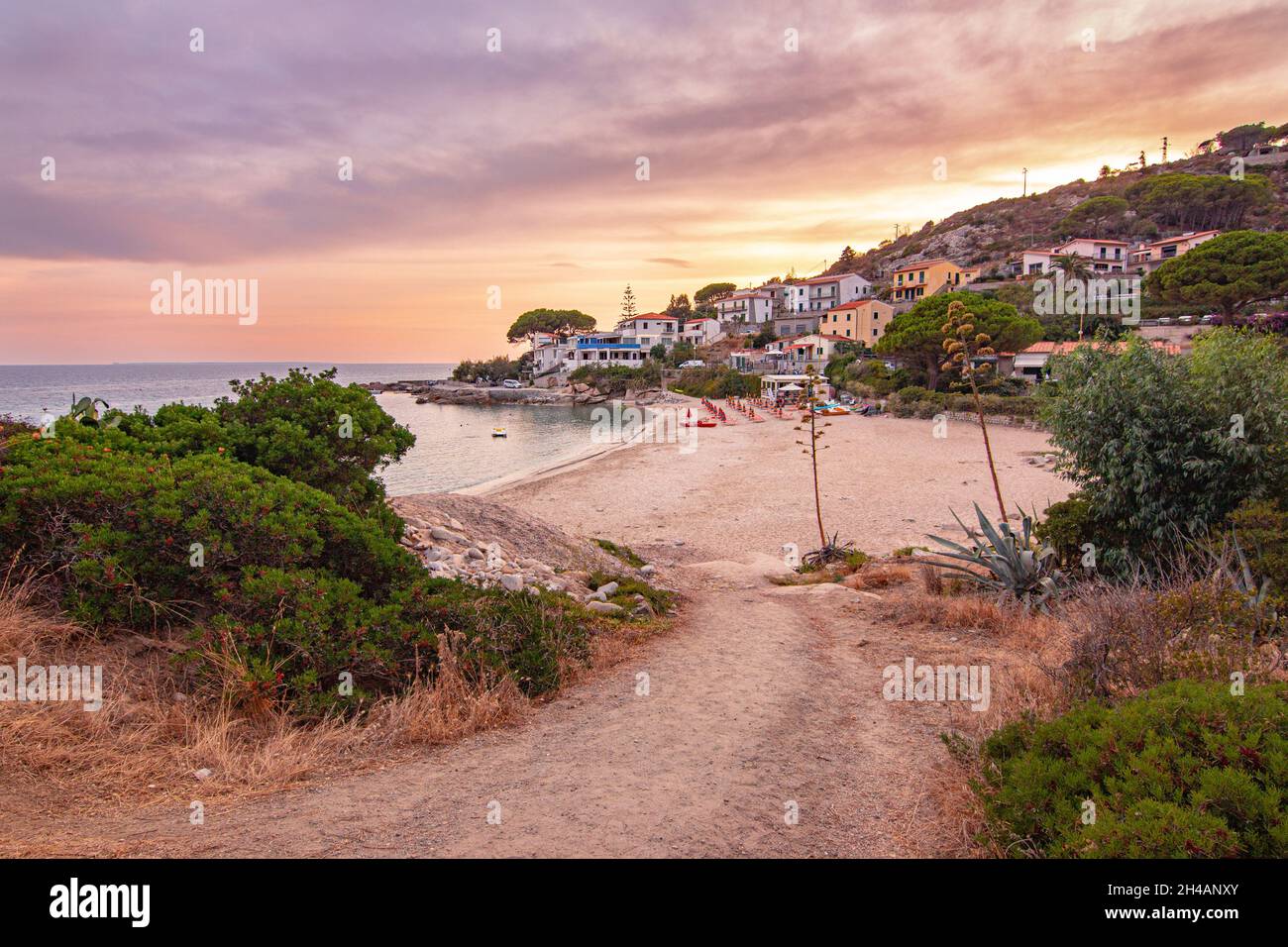 Vista al tramonto sulla spiaggia sabbiosa del piccolo borgo Seccheto a fine stagione all'Isola d'Elba, provincia di Livorno Italia Foto Stock