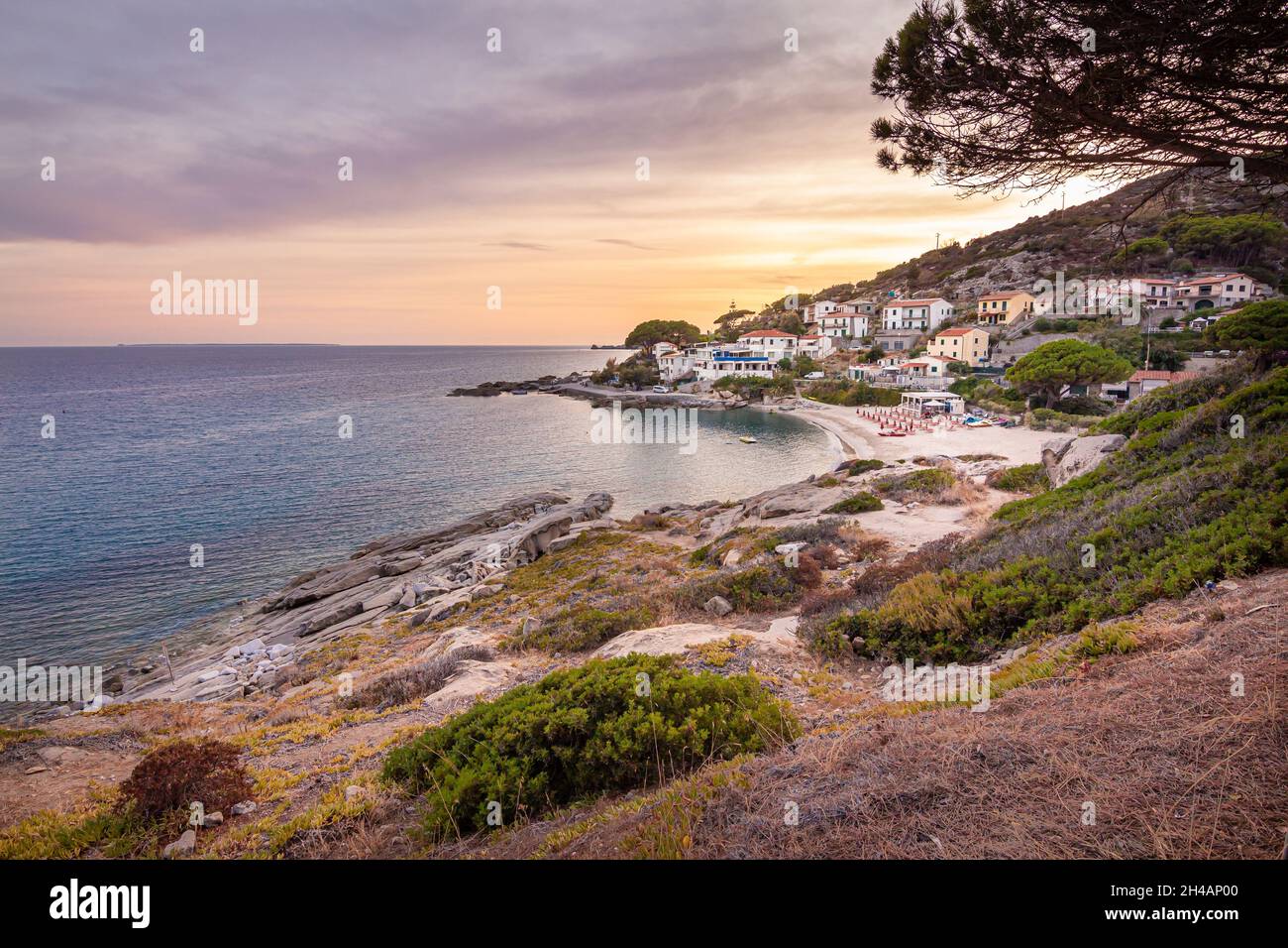 Vista al tramonto sulla spiaggia sabbiosa del piccolo borgo Seccheto a fine stagione all'Isola d'Elba, provincia di Livorno Italia Foto Stock