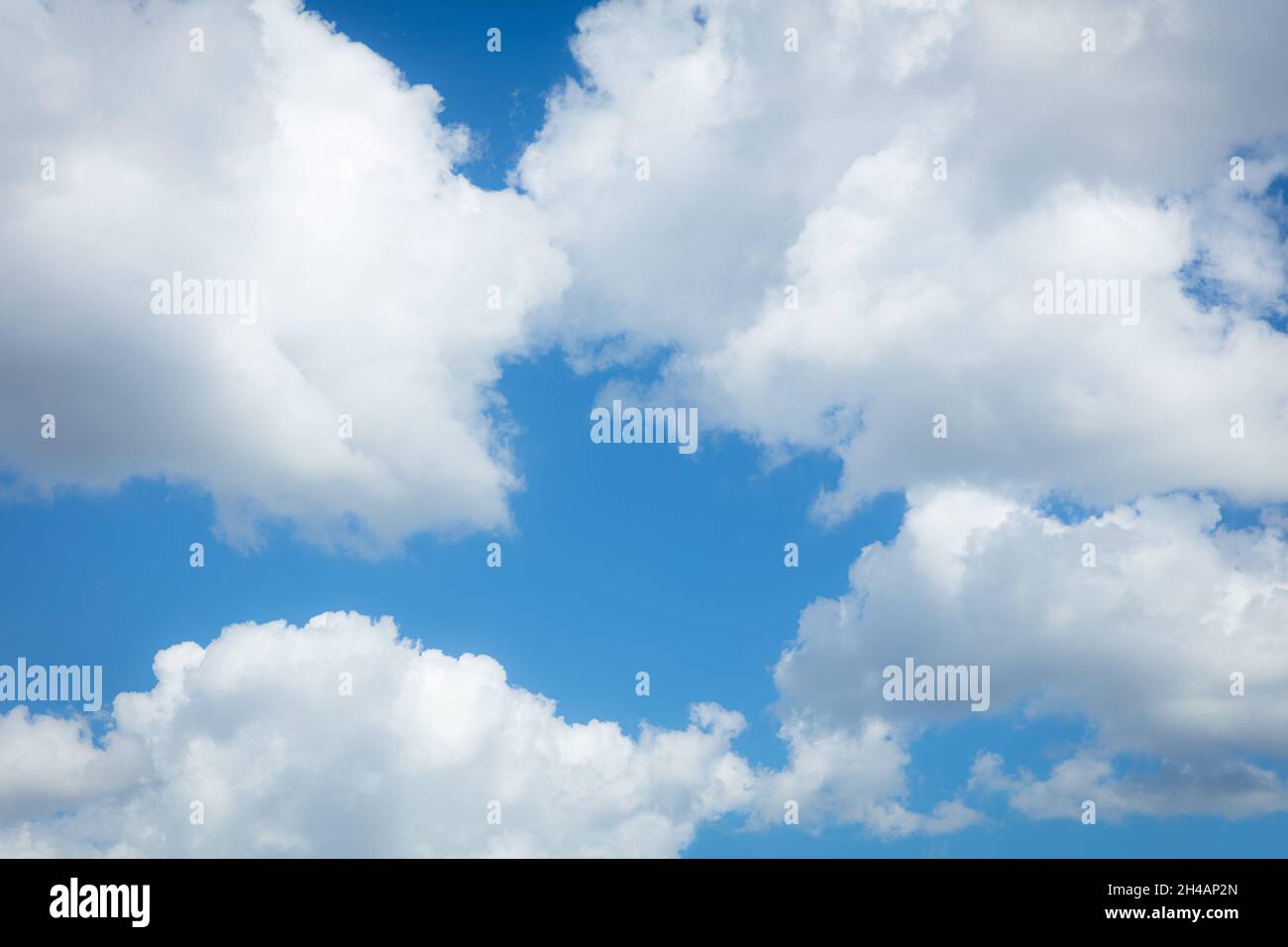 Puffy nuvole bianche contro un cielo blu Foto Stock