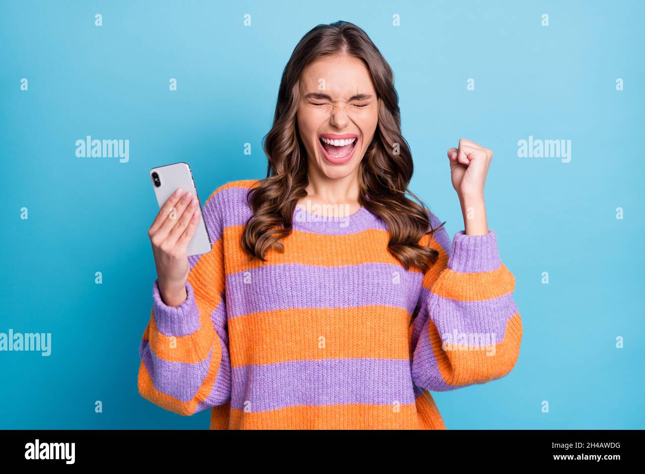 Foto di sorprendente lady pugno su occhi chiusi bocca aperta celebrare il successo seguire isolato su sfondo di colore blu Foto Stock