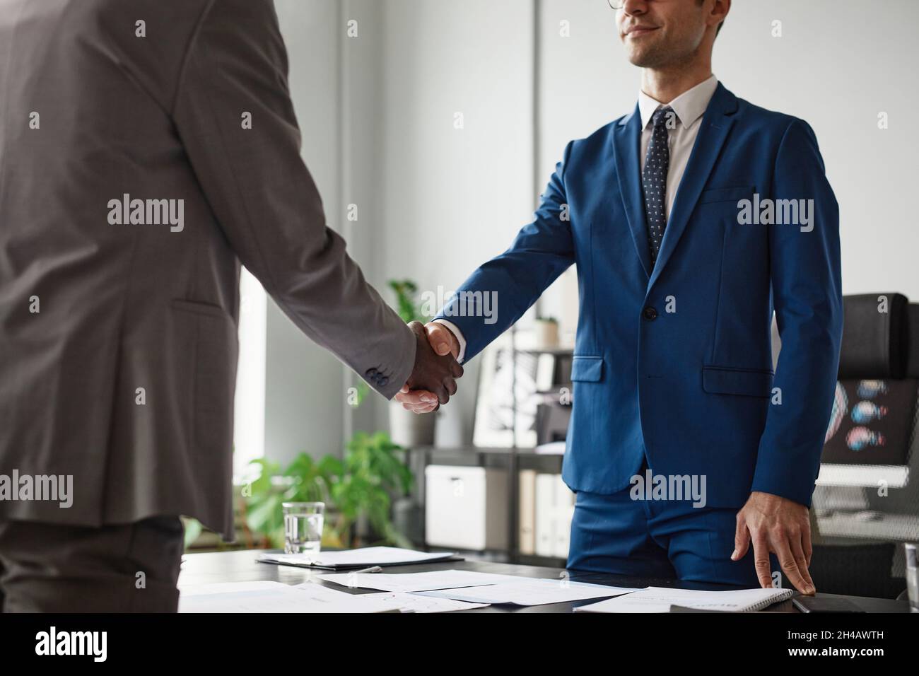 Scatto corto di due uomini d'affari che agita le mani sopra il tavolo durante la riunione in ufficio, spazio di copia Foto Stock