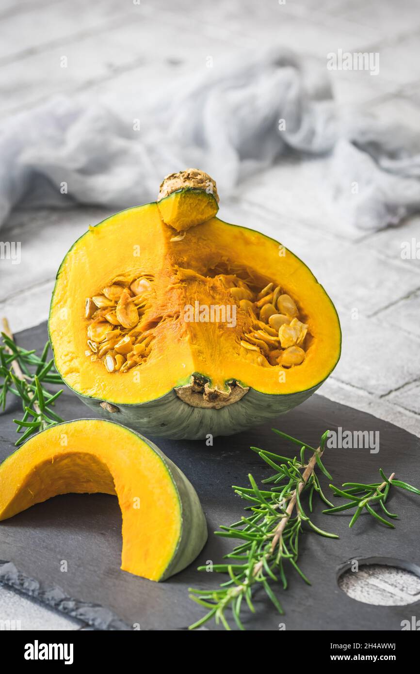 Zucca verde sombra a fette, cucurbita maxima, su sfondo grigio, verticale Foto Stock