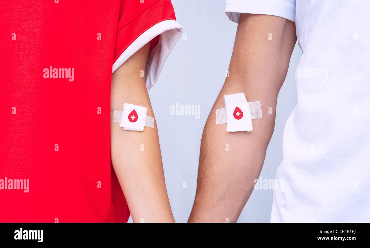 Donazione di sangue. Donatori di sangue di uomo e donna con bendaggio dopo aver dato il sangue. Salvare vite umane. Concetto di giornata mondiale dei donatori di sangue Foto Stock