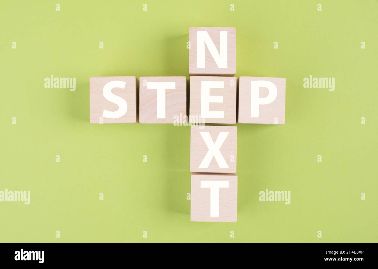 Parola d'incrocio con il passo successivo, la pianificazione di una nuova strategia, la definizione di un obiettivo, sfondo verde colorato Foto Stock