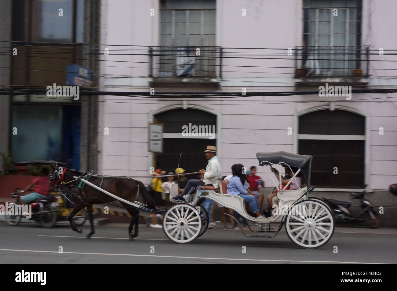 MANILA, FILIPPINE - Mar 16, 2019: Un gruppo di turisti che cavalcano una carrozza trainata da cavalli nella città murata di Intramuros, Manila, Filippine Foto Stock