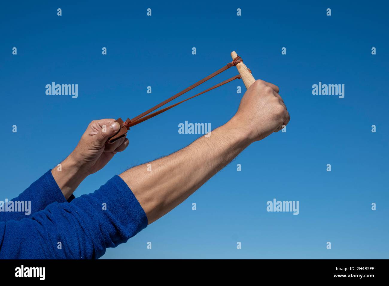 Mani di un uomo che allunga la fascia elastica di un colpo d'ardesia. Foto Stock