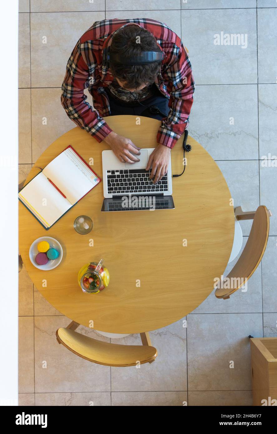 Vista dall'alto dello sviluppatore con un notebook, un notebook, cibo e bevande Foto Stock