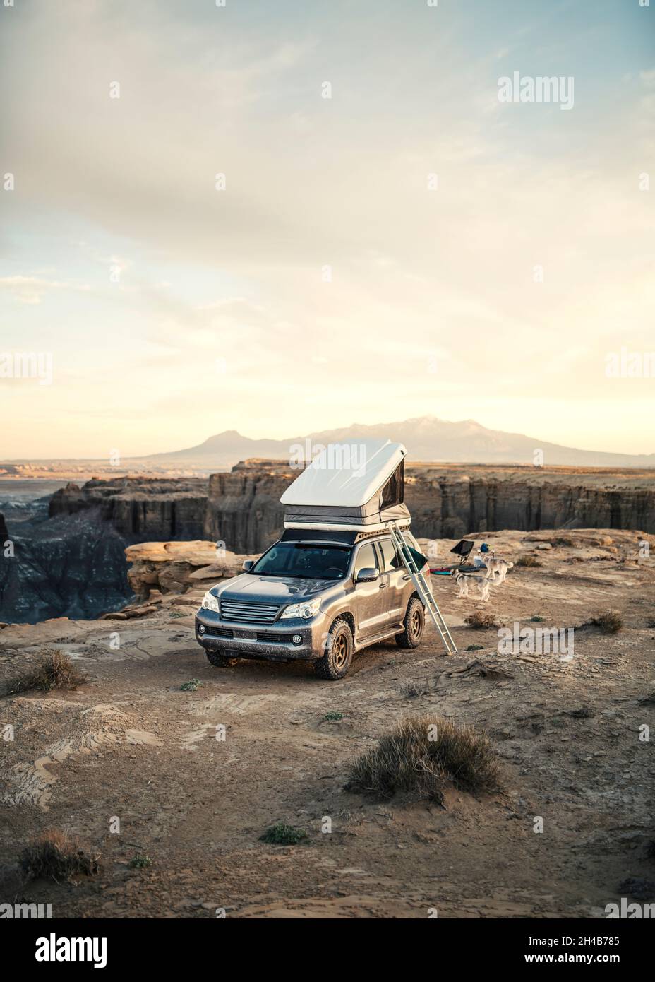 Veicolo 4x4 con tenda sul tetto in campeggio nel deserto al tramonto Foto Stock