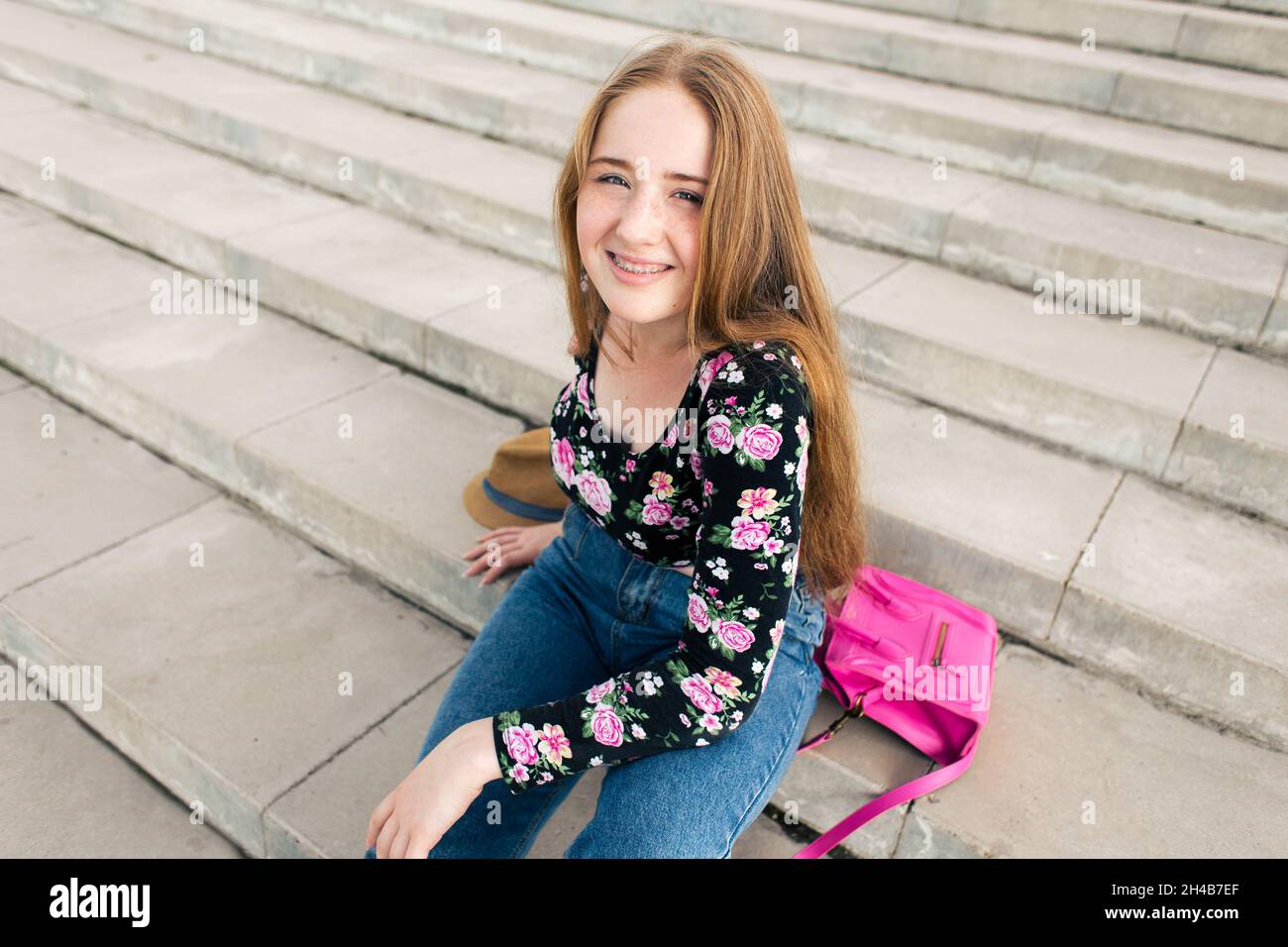 Ragazza adolescente sdraiata sulle scale con accessori Foto Stock