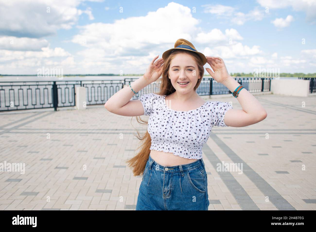 Redhead hipster teen girl con lunghi capelli rossi a piedi nella città estiva Foto Stock
