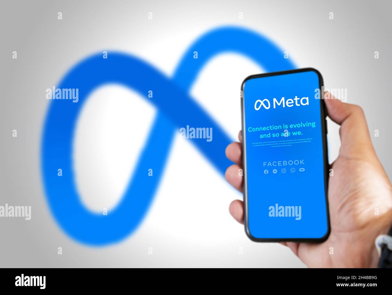 Menlo Park, CA, USA, ottobre 28 2021: Tenere a mano un telefono con l'app mobile Meta sullo schermo e il logo sfocato sullo sfondo. Meta è una te Foto Stock