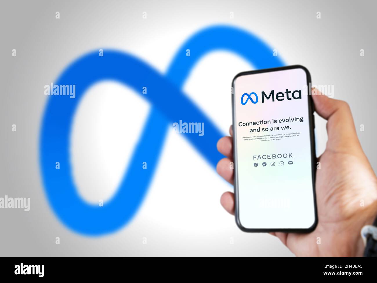 Menlo Park, CA, USA, ottobre 28 2021: Tenere a mano un telefono con l'app mobile Meta sullo schermo e il logo sfocato sullo sfondo. Meta è una te Foto Stock