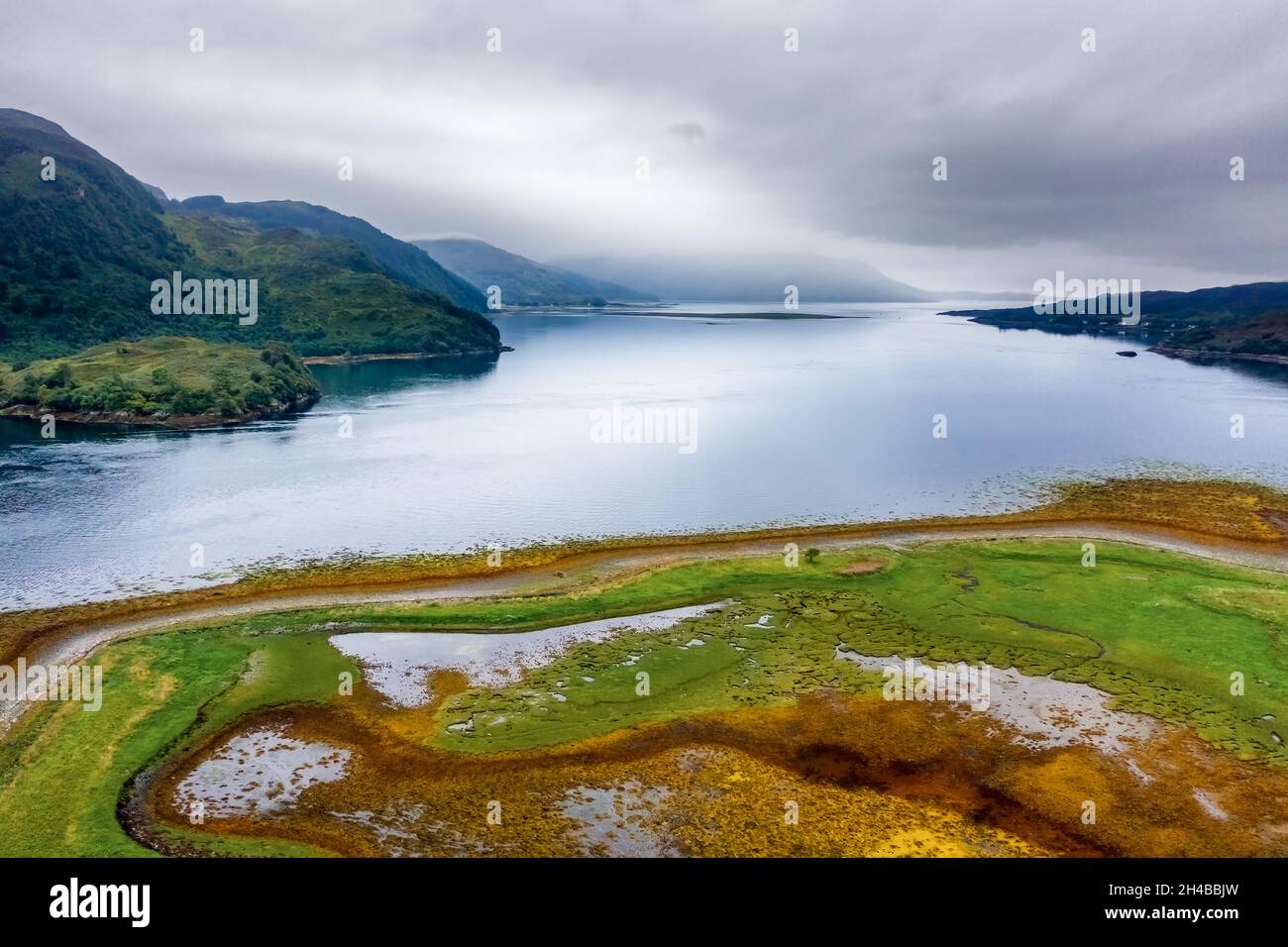 Scenario suggestivo in un lago marino scozzese in un pomeriggio nuvoloso e grigio (Loch Duich, Eilean Donan) Foto Stock