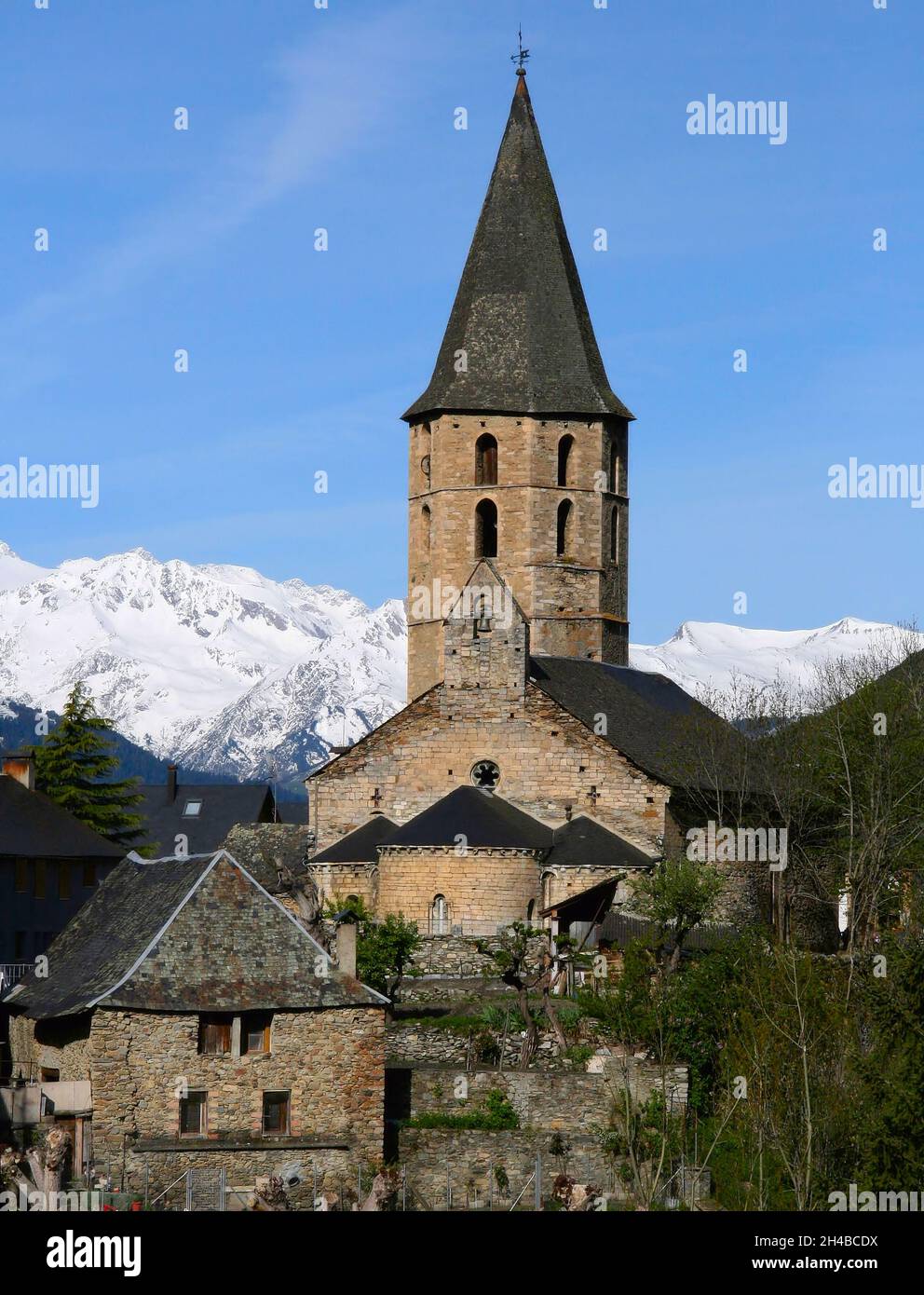 Chiesa di Salardu con il suo grande campanile e guglie e montagne innevate a Salardu, Valle Arun, Pirenei, Spagna Foto Stock