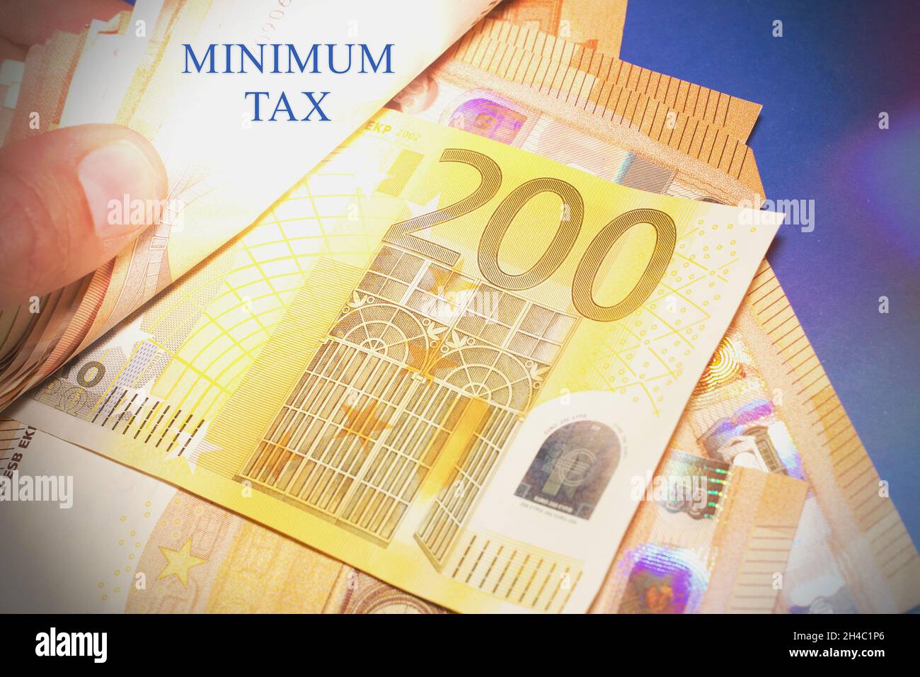 Mano con le banconote in euro e il testo 'Minimun Tax' Foto Stock