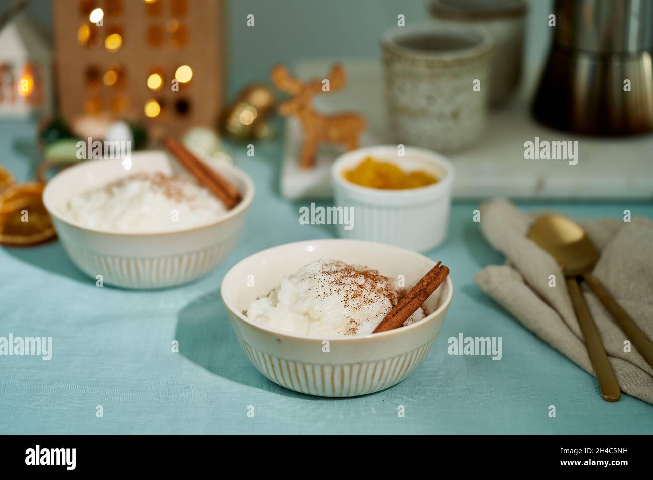 Budino di riso. Dessert al latte francese. Serata o notte di Natale con una luce accogliente di lampada in casa oscura Foto Stock