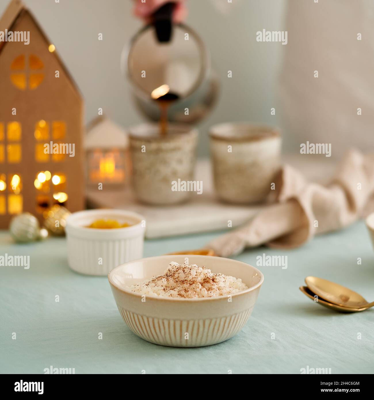 Budino di riso. Donna che versa il caffè dalla macchina per il caffè alla tazza. Decorazione di Natale Foto Stock