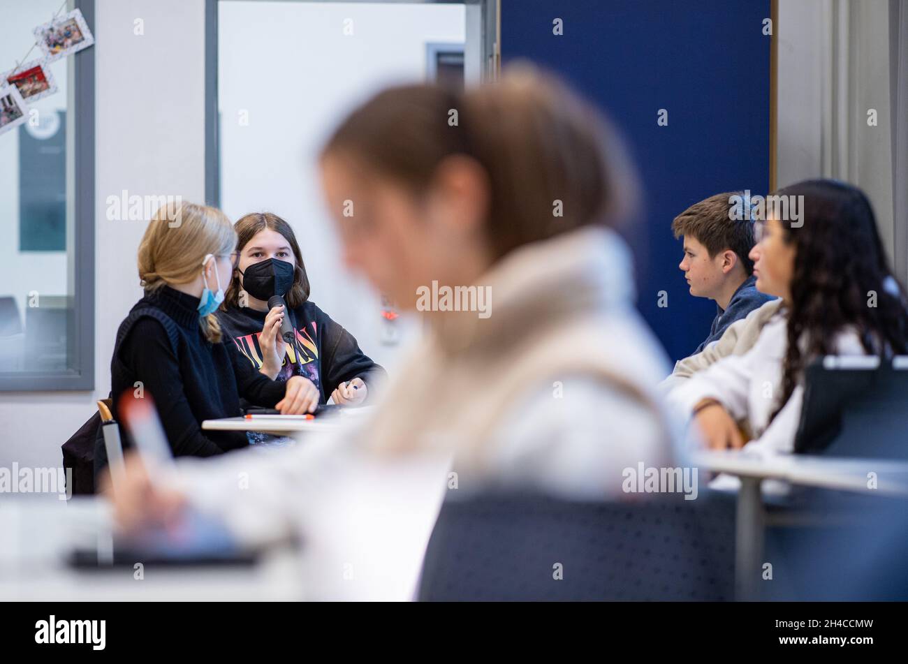 02 novembre 2021, Renania Settentrionale-Vestfalia, Münster: Nel 9° grado di una scuola completa a Münster, gli studenti si siedono parzialmente senza una maschera in classe. Dal 02.11.2021 l'obbligo della maschera nelle scuole al posto in aula è caduto. Gli alunni della Renania Settentrionale-Vestfalia non devono indossare una maschera in classe da martedì, a condizione che si siedano a posti fissi. Tuttavia, il requisito della maschera si applica ancora sulla strada per il sedile e nell'edificio scolastico. Foto: Guido Kirchner/dpa Foto Stock