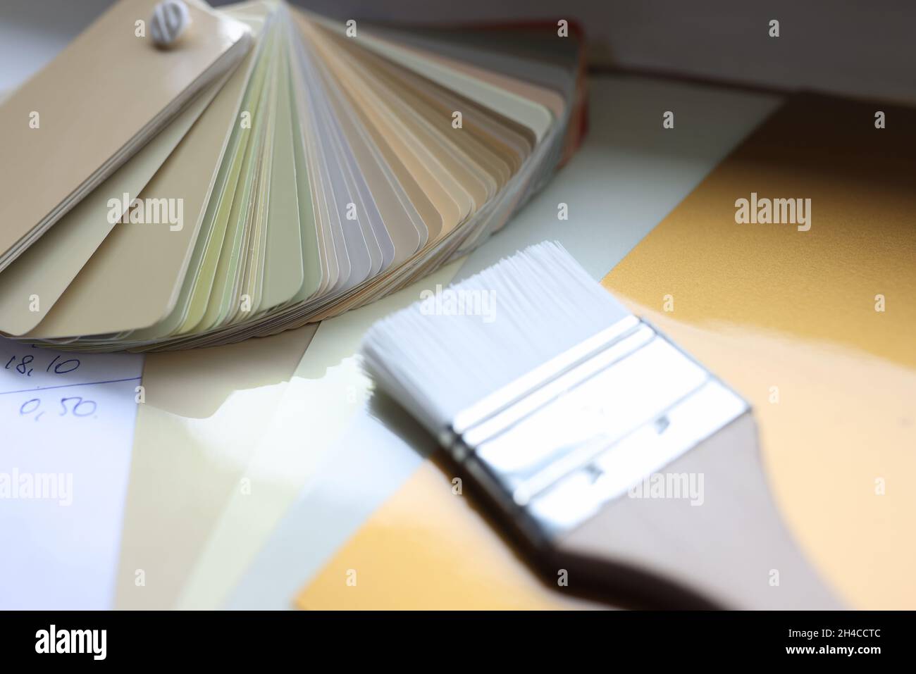 Esempi di una tavolozza di colori e di un pennello giacciono sul tavolo Foto Stock